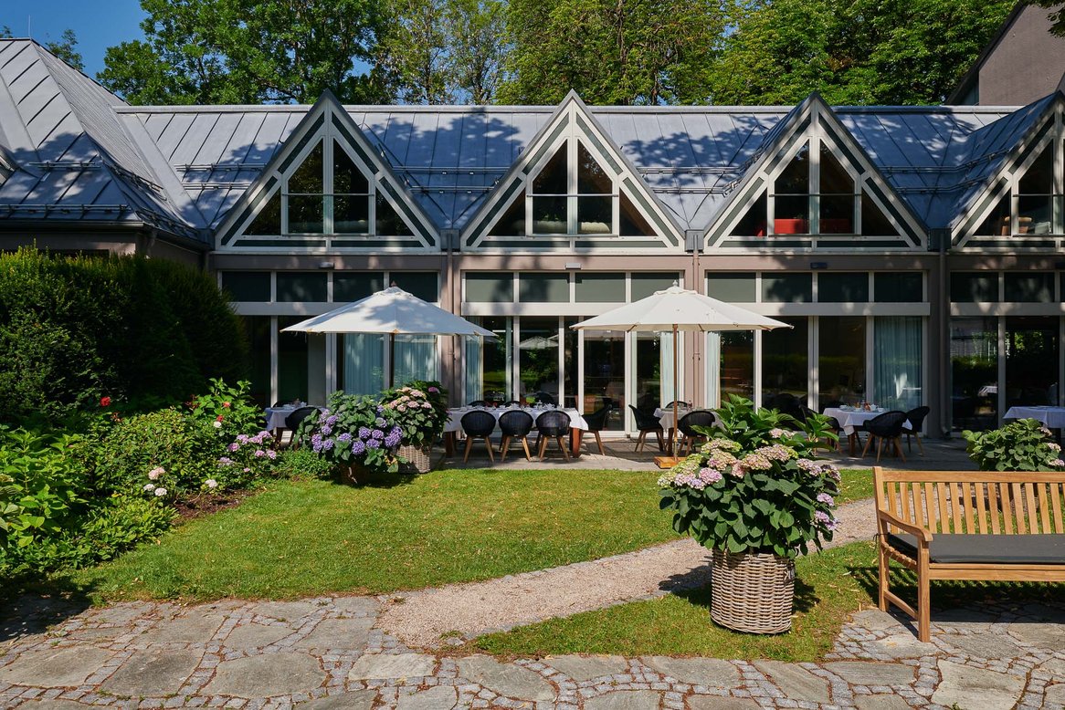 Terrasse mit Sonnenschirmen direkt vor den verglasten Seminarräumen
